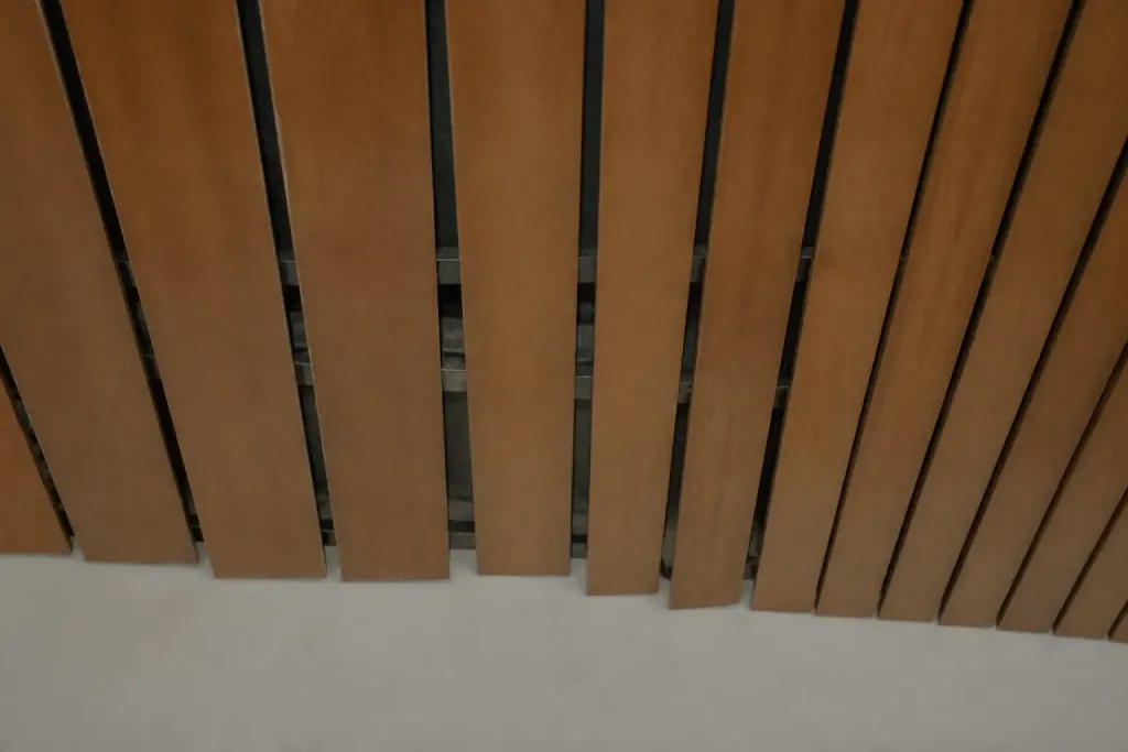 Lames de plafond mal alignées avec espacement irrégulier visible