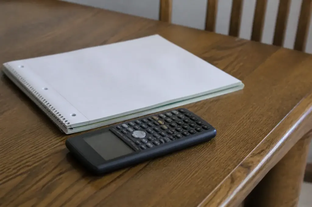 Carnet de notes et calculatrice poses sur une table