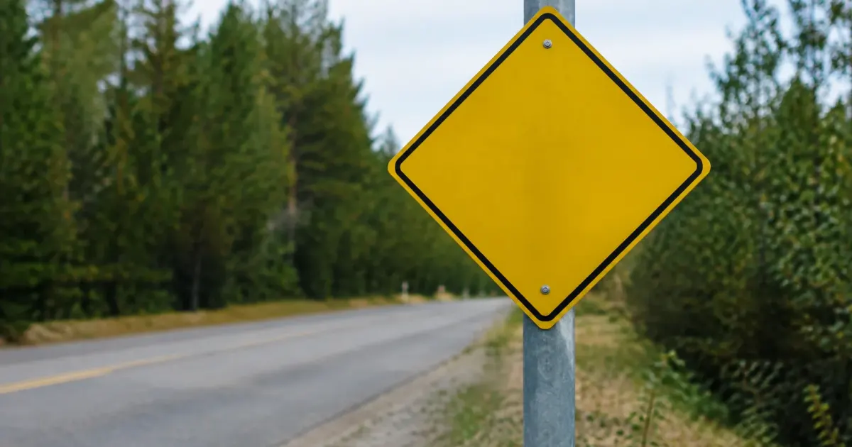 Panneau jaune de signalisation fixe sur poteau gris