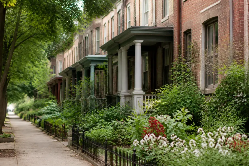 Rangée de maisons en briques avec jardins verts