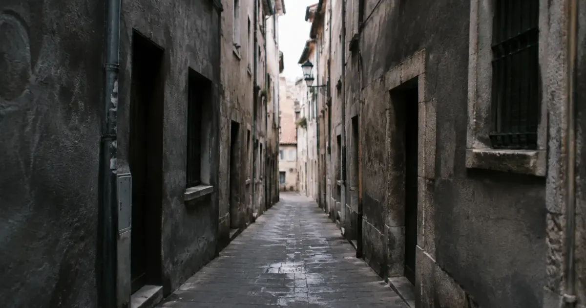 Rue etroite avec facades usees des immeubles gris sombres