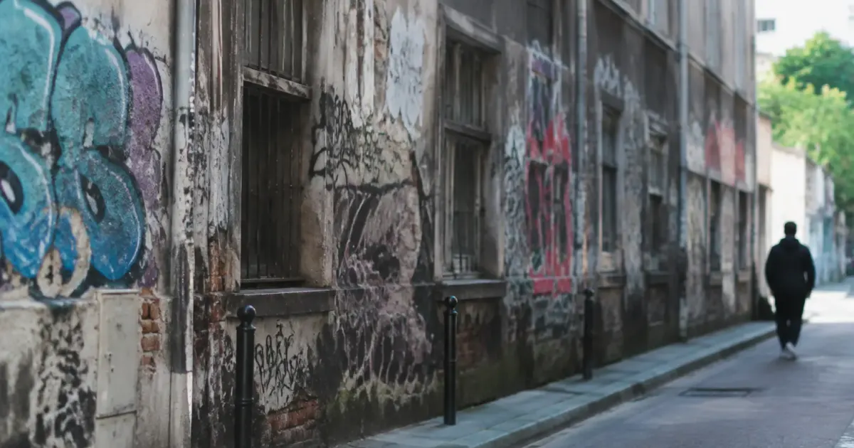 Rue urbaine sombre facade degradee graffitis couvrant murs